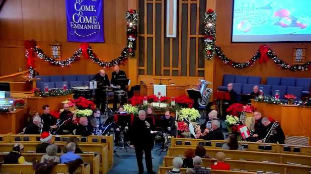 The Brass Factory conductor speaking during the 2025 concert at PVURC.