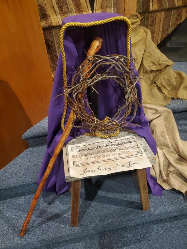 Close-up view of the "Jesus King of the Jews" sign and crown of thorns in a Good Friday diorama display.