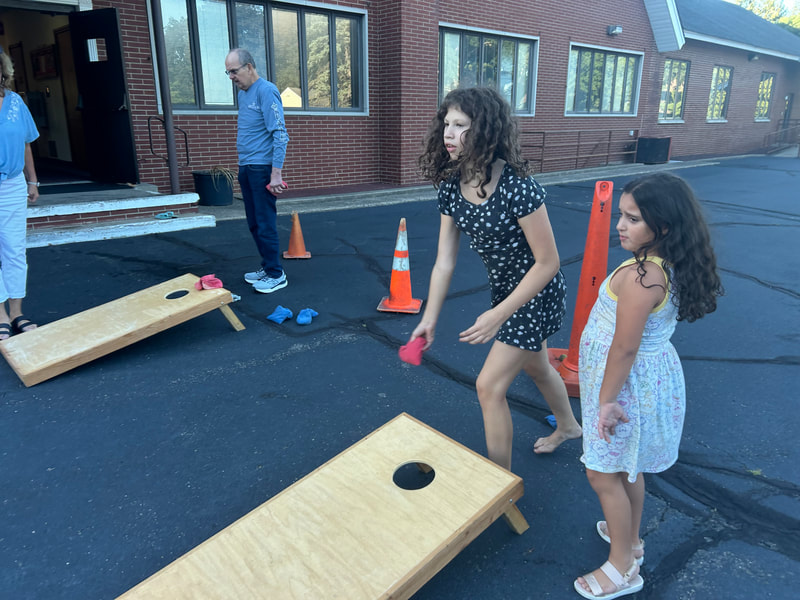 Children playing cornhole at the PVURC church picnic.